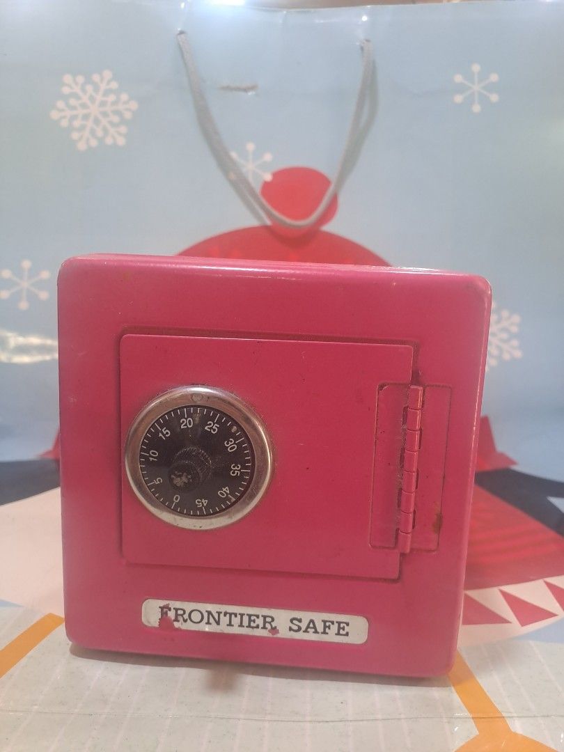 Frontier Safe Pink Combination Lock box Bank (Category: Safe) located in Davao. Submitted by bravemoon_556cd5 (Listing ID 1455296784, Image 1). Description: - Pink metal piggy bank - Features a combination lock for security - Slot for both coins and bills - Easy access storage compartment - Opening instructions located on the bottom - Distributed by Five Below, Inc. - Made in Taiwan - Shows minor scuffs from previous use.