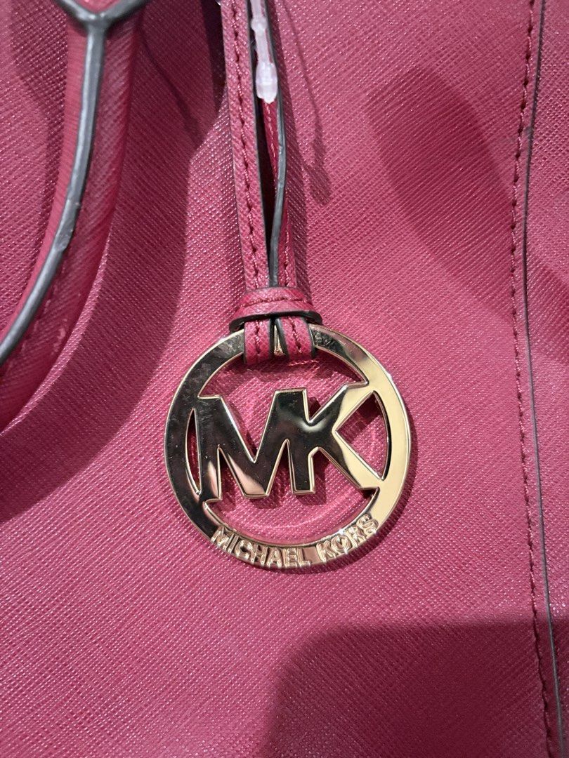 Michael Kors Red Leather Satchel Handbag (Category: Luxury Bags & Wallets) located in Caloocan City. Submitted by fierce_mica29 (Listing ID 1455199985, Image 2). Description: - Authentic Michael Kors handbag - Vibrant red color - Made from quality leather - Iconic MK logo charm - Multiple zippered compartments for organization - Stylish gold-tone hardware - Perfect for everyday use.