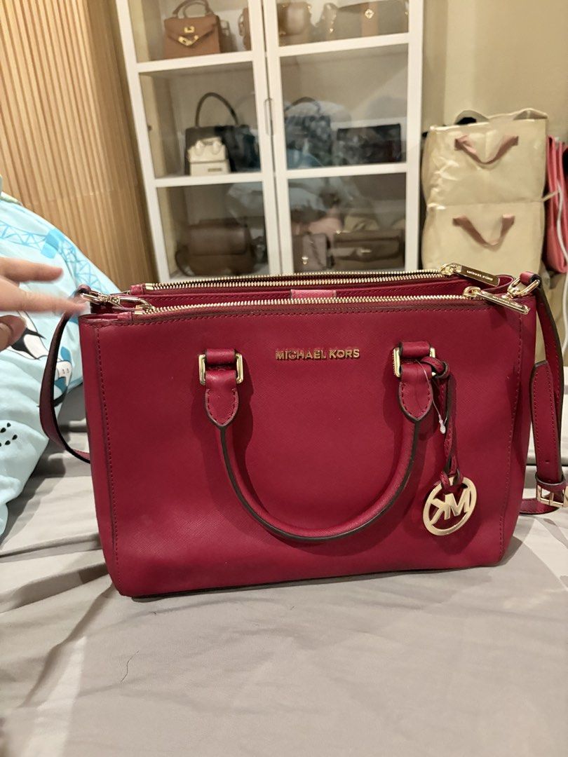 Michael Kors Red Leather Satchel Handbag (Category: Luxury Bags & Wallets) located in Caloocan City. Submitted by fierce_mica29 (Listing ID 1455199985, Image 1). Description: - Authentic Michael Kors handbag - Vibrant red color - Made from quality leather - Iconic MK logo charm - Multiple zippered compartments for organization - Stylish gold-tone hardware - Perfect for everyday use.