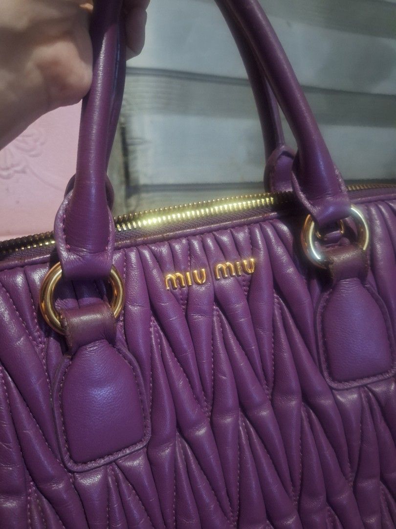 MIUMIU Matelasse Hand Bag (Category: Luxury Bags & Wallets) located in Quezon City. Submitted by cloudymay (Listing ID 1452367525, Image 1). Description: - Authentic Miu Miu Matelasse Bag - Sexy Purple color - Secure zip closure with LAMPO underzip and MiuMiu Puller logo - Interior white tag - made in Italy - Great gold signature hardwares - Handbag only, no strap. - normal signs of use, minor rubs and corner leather wear off - Bag looks very pre