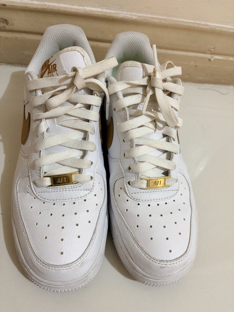 Nike Air Force 1 '07 Gold Sneakers (Category: Sneakers) located in Paranaque City. Submitted by aacc0920 (Listing ID 1455205190, Image 1). Description: - Classic white Nike Air Force 1 '07 - Features gold accents on Nike Air logo and lace tag - Great for everyday wear - Selling because they no longer fit.