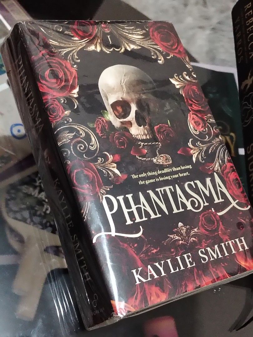 PHANTASMA by Kaylie Smith (Category: Storybooks) located in Manila. Submitted by shajii (Listing ID 1455296446, Image 2). Description: PHANTASMA - Author: Kaylie Smith - Genre: Dark Fantasy / Thriller - Cover Design: Features a skull and roses motif - Tagline: "The only thing deadlier than losing the game is losing your heart." - Ideal For: Fans of dark fantasy and thrillers binasa lang onti lolll. can send more pics ~ sdd, jnt or meet up gcash, 