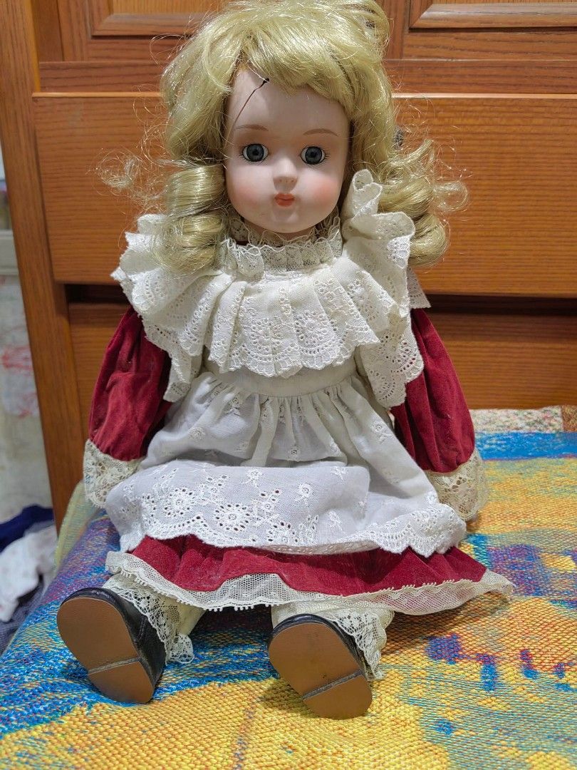 Porcelain Doll (Category: Figurines & Statues) located in Cebu City. Submitted by dudes_villanueva (Listing ID 1455226994, Image 2). Description: Porcelain Doll 📌 features a Victorian-style layered lace dress with red velvet sleeves and blonde curly hair. 📌 Crafted with a bisque porcelain head, hands, and lower limbs, paired with a soft body and detailed fabric costuming. 📌Styled with traditional painted facial features, fixed blue glass-like 