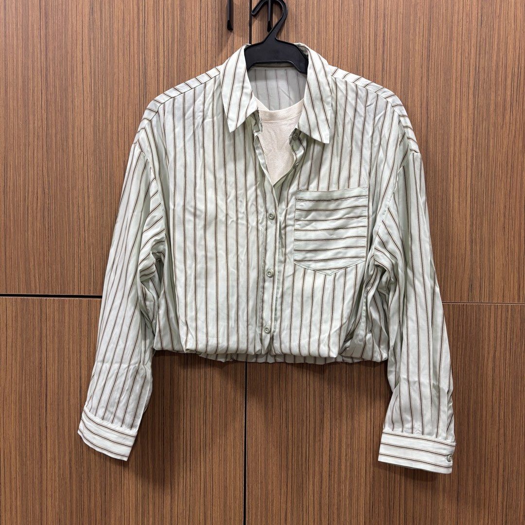 Striped Cropped Shirt with Inner Tank (Category: Shirts) located in Manila. Submitted by inationg (Listing ID 1455238627, Image 1). Description: - Light green and brown striped cropped shirt - Features a pocket on the left chest - Comes with a cream-colored ribbed inner tank - Button-up front closure - Elasticated hem for a comfortable fit - Perfect for layering or wearing as a standalone piece.