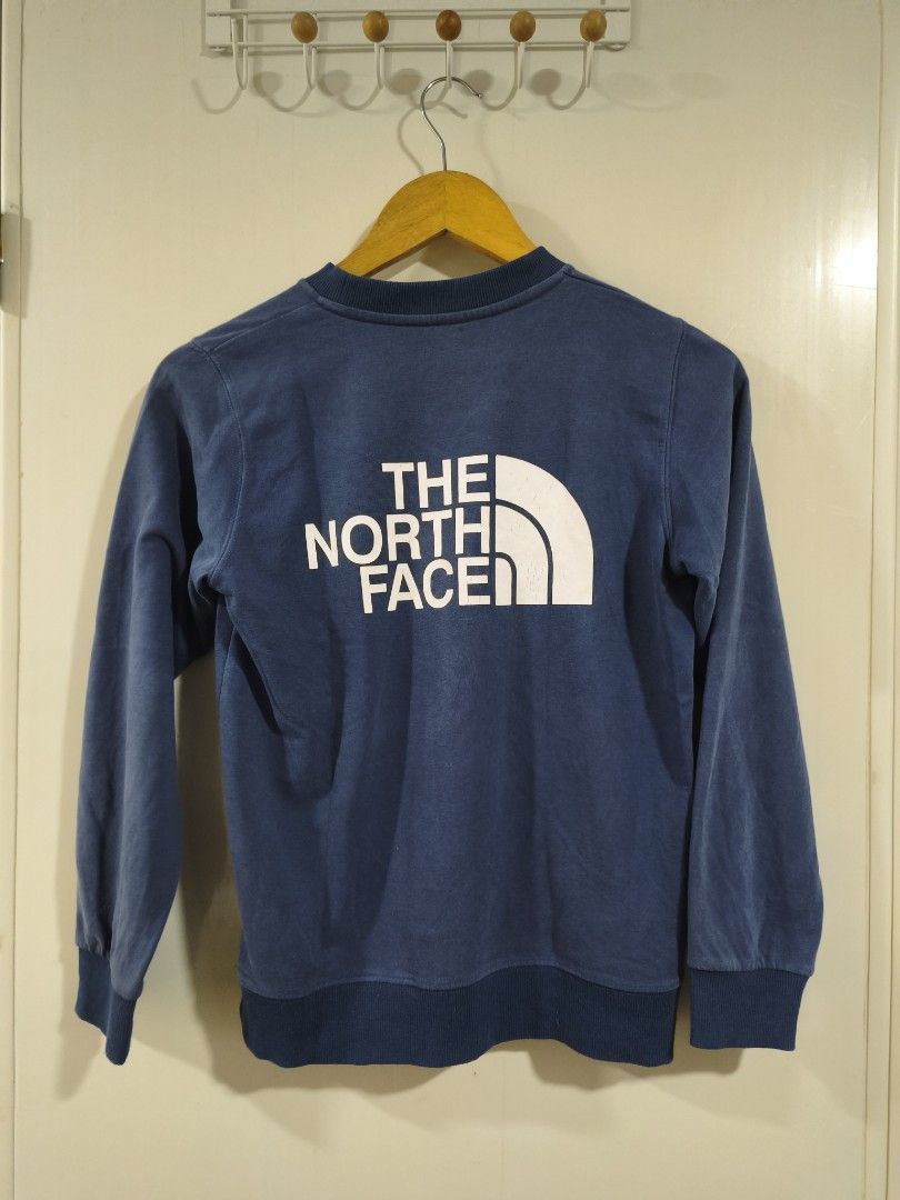 The North Face Blue Cotton Sweatshirt (Category: Babies & Kids Fashion) located in Iloilo. Submitted by daddy_declutter (Listing ID 1455318289, Image 2). Description: L 21 x W 17 Blue crewneck sweatshirt from The North Face. Features the classic logo on the front and a larger logo on the back. Made from 100% cotton. Ribbed cuffs and hem. Great for casual wear..
