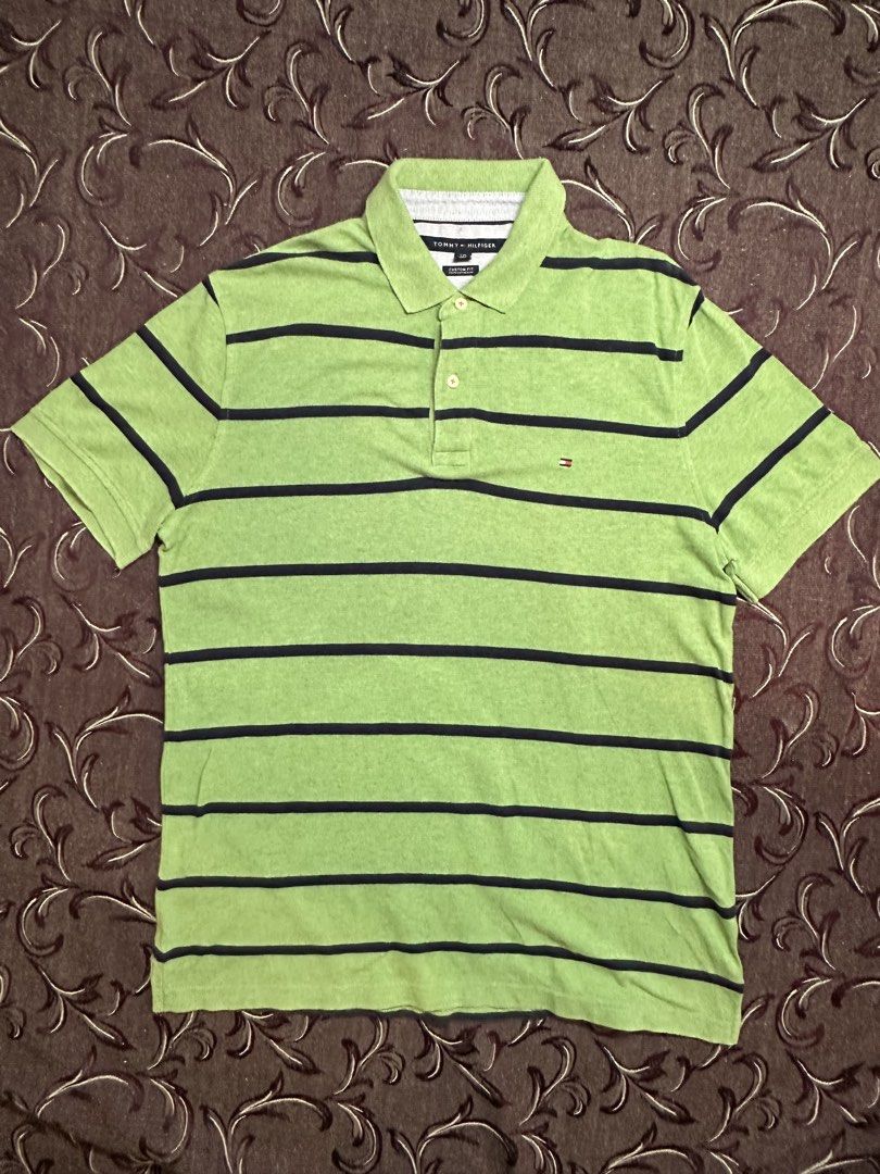 Tommy Hilfiger Custom Fit Striped Polo (Category: Tshirts & Polo Shirts ) located in Silang. Submitted by ws.thrift (Listing ID 1454244498, Image 2). Description: Tommy Hilfiger Custom Fit Striped Polo Color: Green / Navy Classic Tommy Hilfiger polo featuring horizontal navy stripes, collared neckline, 2-button placket, and signature Tommy flag logo on the chest. Made from comfortable cotton with a timeless everyday look. Size: L Fit: Custom Fit 