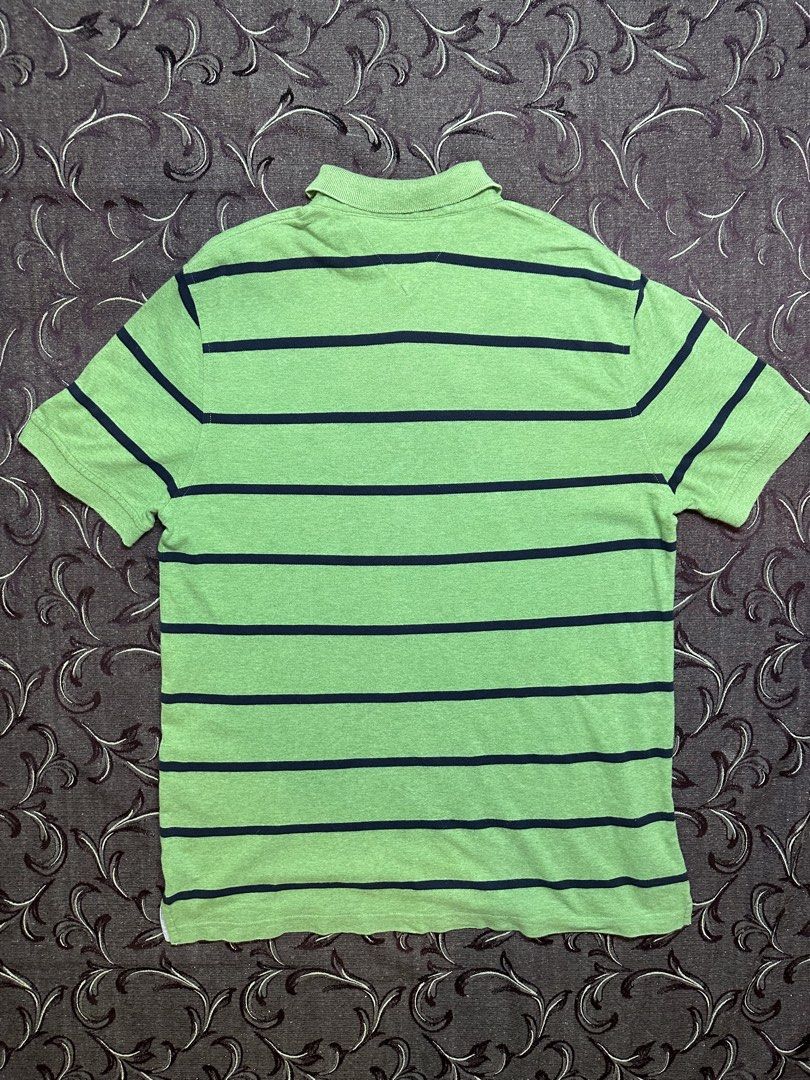 Tommy Hilfiger Custom Fit Striped Polo (Category: Tshirts & Polo Shirts ) located in Silang. Submitted by ws.thrift (Listing ID 1454244498, Image 3). Description: Tommy Hilfiger Custom Fit Striped Polo Color: Green / Navy Classic Tommy Hilfiger polo featuring horizontal navy stripes, collared neckline, 2-button placket, and signature Tommy flag logo on the chest. Made from comfortable cotton with a timeless everyday look. Size: L Fit: Custom Fit 