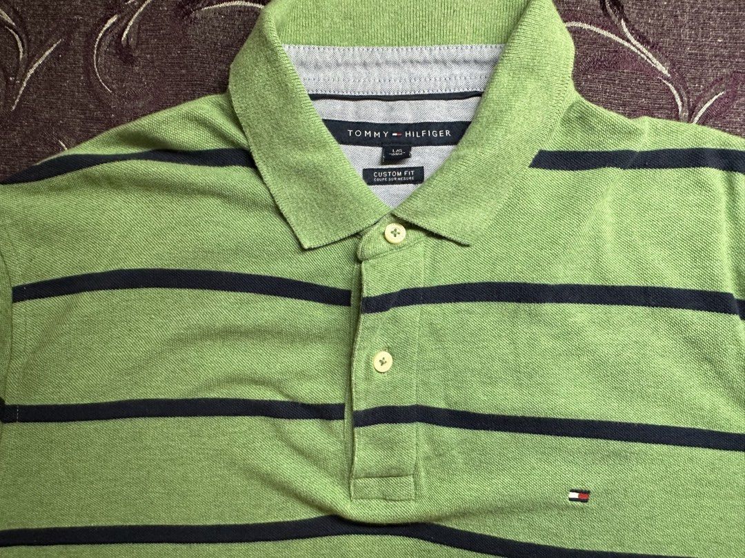 Tommy Hilfiger Custom Fit Striped Polo (Category: Tshirts & Polo Shirts ) located in Silang. Submitted by ws.thrift (Listing ID 1454244498, Image 1). Description: Tommy Hilfiger Custom Fit Striped Polo Color: Green / Navy Classic Tommy Hilfiger polo featuring horizontal navy stripes, collared neckline, 2-button placket, and signature Tommy flag logo on the chest. Made from comfortable cotton with a timeless everyday look. Size: L Fit: Custom Fit 