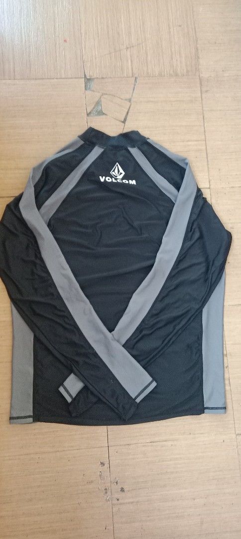 Volcom Long Sleeve Rash Guard XL Black Grey (Category: Activewear) located in Koronadal. Submitted by gifts.thrifts (Listing ID 1455320199, Image 2). Description: - Volcom Long Sleeve Rash Guard - Size: XL - Color: Black with Grey Sleeves and Side Panels - Features: Volcom logo on front and back - Material: 82% Nylon, 18% Spandex - Benefits: Excellent sun protection for water activities.