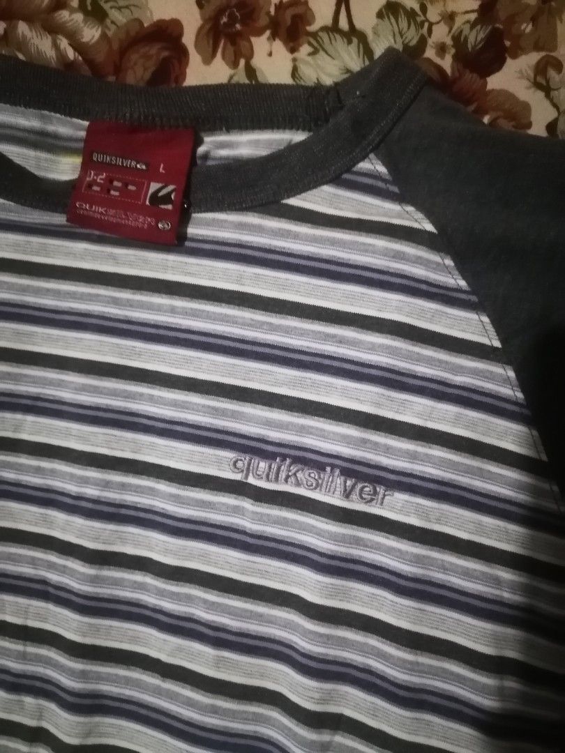 VTG QUICKSILVER Crew Neck (Category: Hoodies) located in San Carlos City. Submitted by apyogone (Listing ID 1455318800, Image 2). Description: vintage or older-season Quiksilver striped long-sleeve raglan shirt featuring solid charcoal grey sleeves, a matching crew neck trim, and a thin grey-and-white horizontally striped body with a subtle embroidered logo across the chest. Size Large.