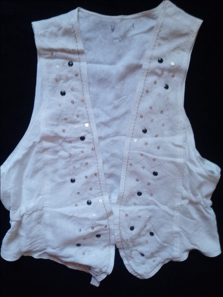 White Sleeveless Vest with Sequins and Beads (Category: Sleeveless) located in Pasig City. Submitted by marjukka (Listing ID 1455213493, Image 2). Description: Chic white sleeveless vest with bead and sequin embellishments. Features an open front, ruffled back hem with a tie, and lightweight material perfect for layering..