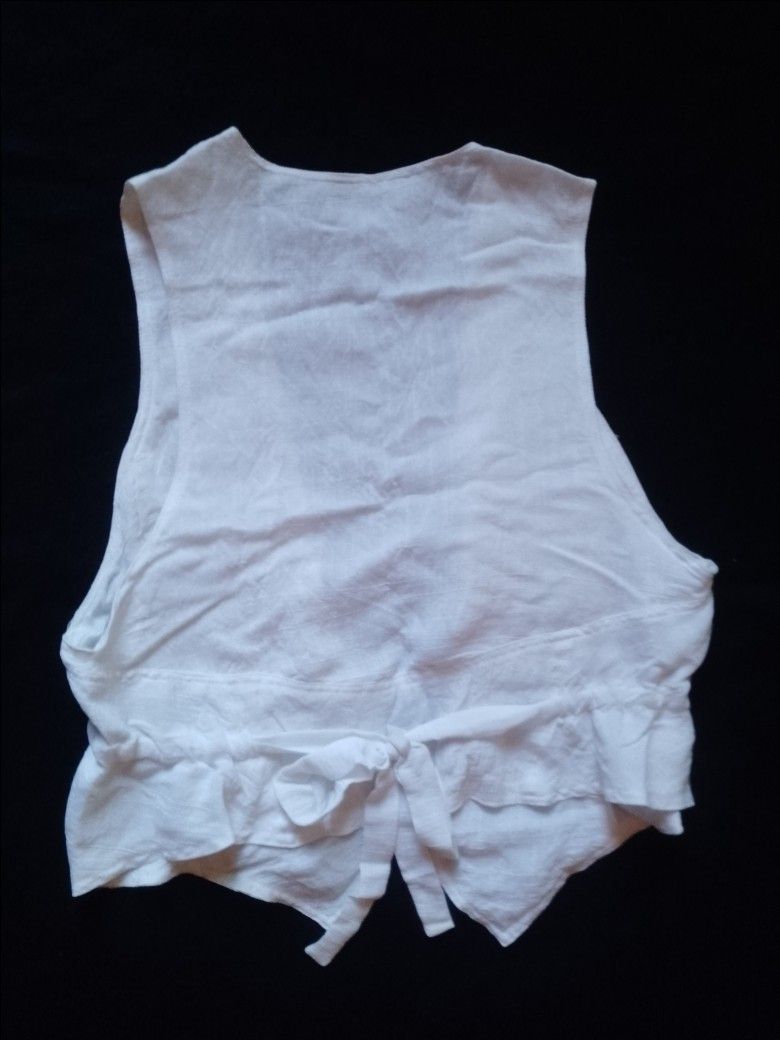 White Sleeveless Vest with Sequins and Beads (Category: Sleeveless) located in Pasig City. Submitted by marjukka (Listing ID 1455213493, Image 3). Description: Chic white sleeveless vest with bead and sequin embellishments. Features an open front, ruffled back hem with a tie, and lightweight material perfect for layering..