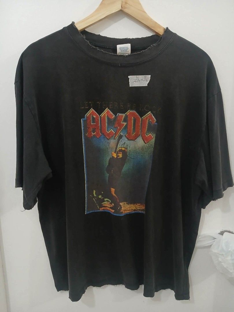 AC/DC Let There Be Rock T-Shirt (Category: Tshirts & Polo Shirts ) located in Manila. Submitted by bonifacioc73501 (Listing ID 1455423595, Image 1). Description: - Vintage AC/DC T-shirt - Features 'Let There Be Rock' album graphic - Distressed neckline and hem for a worn-in look - Size: Large (L) - Measurements: 26.5 inches length x 24 inches width - Ideal for any rock music enthusiast.
