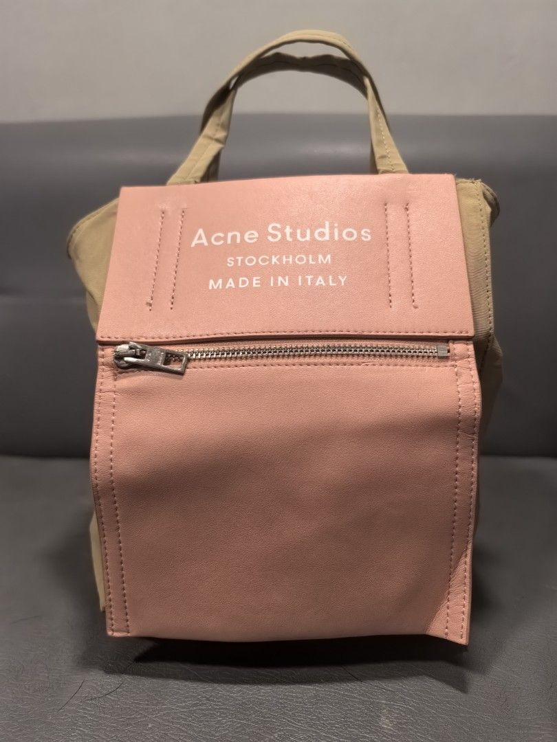 Acne studios baker out small tote (Category: Luxury Bags & Wallets) located in Cagayan de Oro. Submitted by pootx (Listing ID 1455433591, Image 1). Description: - Authentic Acne Studios tote bag - Made in Italy - Stylish tan canvas body - Features a pink leather front panel with a secure zip pocket - Comfortable tan handles - Durable tan interior lining - Approximately 10 inches wide.