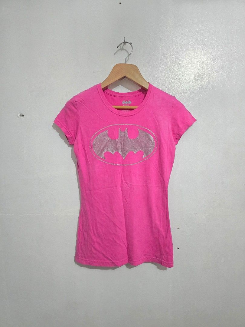 Batman Pink T-Shirt Size L (Category: Shirts) located in Quezon City. Submitted by eivan____orong (Listing ID 1455327179, Image 1). Description: - Pink t-shirt with silver Batman logo - Made in Mexico - 100% Cotton - Care: Machine wash cold, non-chlorine bleach only, tumble dry low - Do not iron if decorated - Ideal for any Batman fan! - Y2k vibes - (28L x 18W).