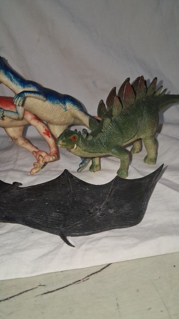 Bundle of Dinosaur and Pterodactyl Toy Figures (Category: Figurines & Statues) located in Manila. Submitted by marcas022798212 (Listing ID 1455366943, Image 3). Description: - Large yellow Pterodactyl figure - Green Stegosaurus figure - Assorted small raptor-like dinosaurs (blue, red, tan) - Large black bat figure - Ideal for imaginative play and display - Some figures show minor paint wear.