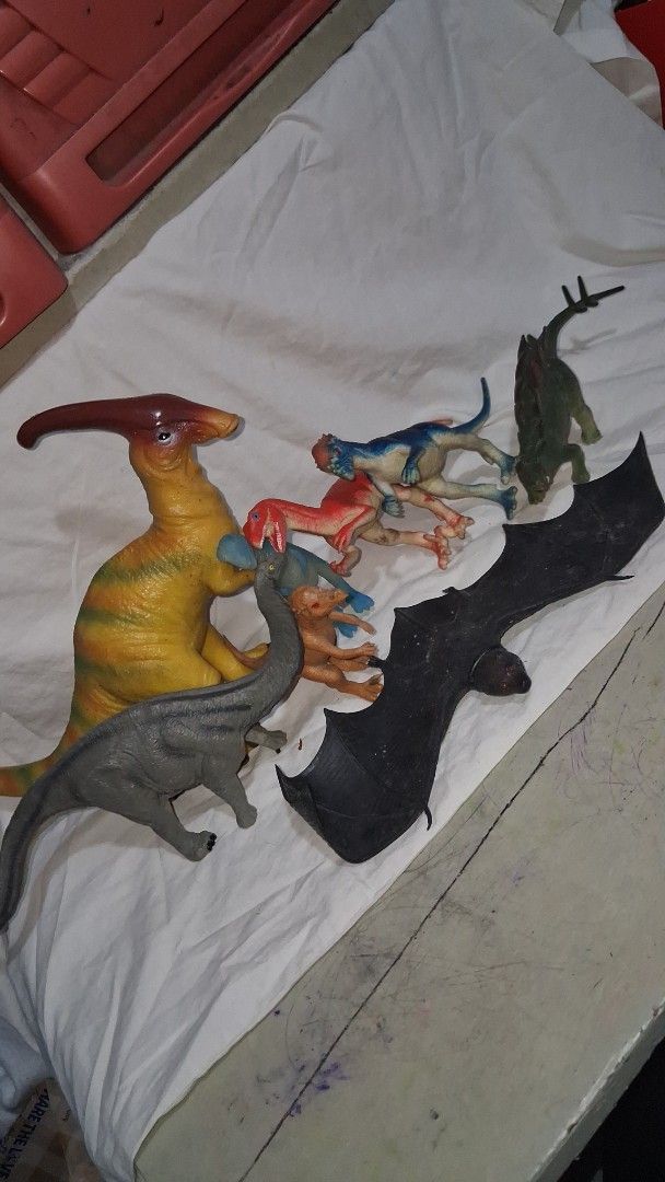 Bundle of Dinosaur and Pterodactyl Toy Figures (Category: Figurines & Statues) located in Manila. Submitted by marcas022798212 (Listing ID 1455366943, Image 1). Description: - Large yellow Pterodactyl figure - Green Stegosaurus figure - Assorted small raptor-like dinosaurs (blue, red, tan) - Large black bat figure - Ideal for imaginative play and display - Some figures show minor paint wear.