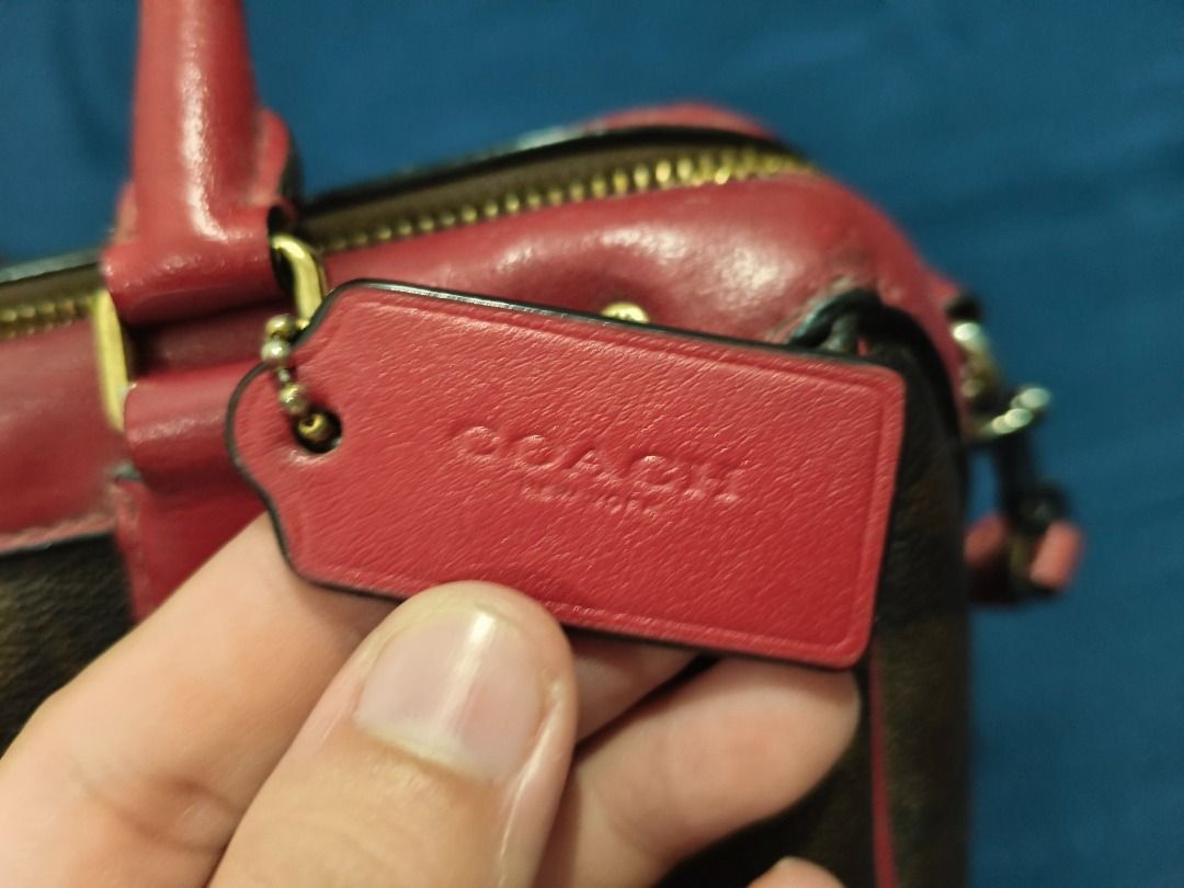 Coach Monogram Canvas and Leather Satchel Bag (Category: Luxury Bags & Wallets) located in Manila. Submitted by marge129557 (Listing ID 1455378118, Image 3). Description: - Authentic Coach satchel bag - Classic monogram canvas with red leather trim - Top handles and detachable crossbody strap - Gold hardware details - Secure zipper closure - Ideal size for everyday essentials - Stylish and versatile issue: no creed, replaced sling.