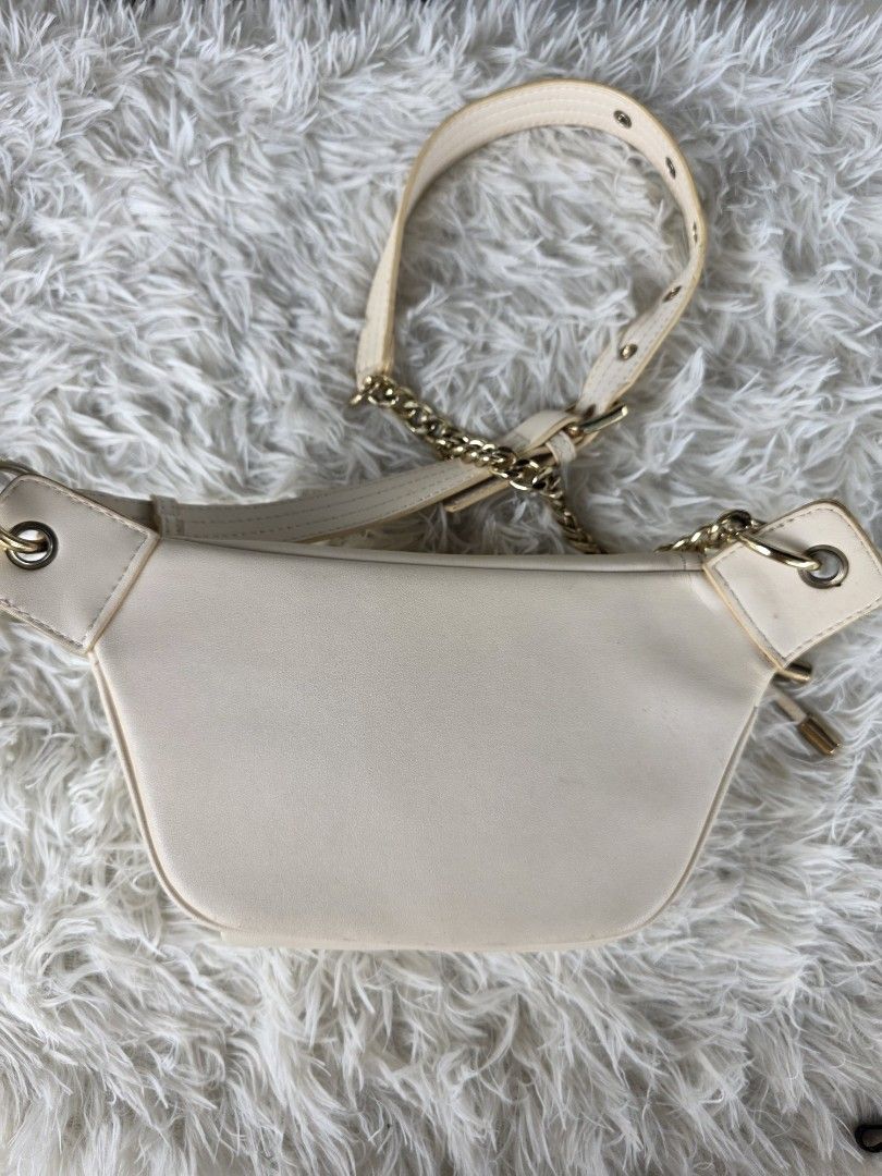 Cream Mickey Mouse Fanny Pack with Gold Chain Strap (Category: Cross-body Bags) located in Lemery. Submitted by venus23 (Listing ID 1455325251, Image 2). Description: - Cream colored fanny pack - Features a cute Mickey Mouse graphic on the front - Zipper closure - Gold chain strap with adjustable buckle - Can be worn as a crossbody or around the waist - Approximate measurements: 7 inches wide x 5 inches tall.