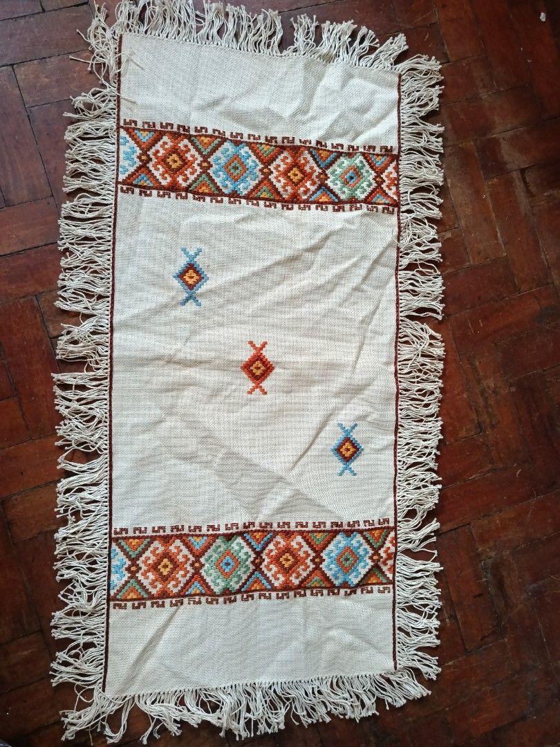 Handmade Embroidered Table Runner with Fringe (Category: Table Linen & Textiles) located in Manila. Submitted by at.iba.pa (Listing ID 1455394521, Image 1). Description: - Cream-colored table runner - Features colorful geometric embroidery - Fringe on both ends - Approximate dimensions: 30 inches long x 10 inches wide - Perfect for adding a decorative touch to dining tables or entryway consoles - Unique, handmade piece.