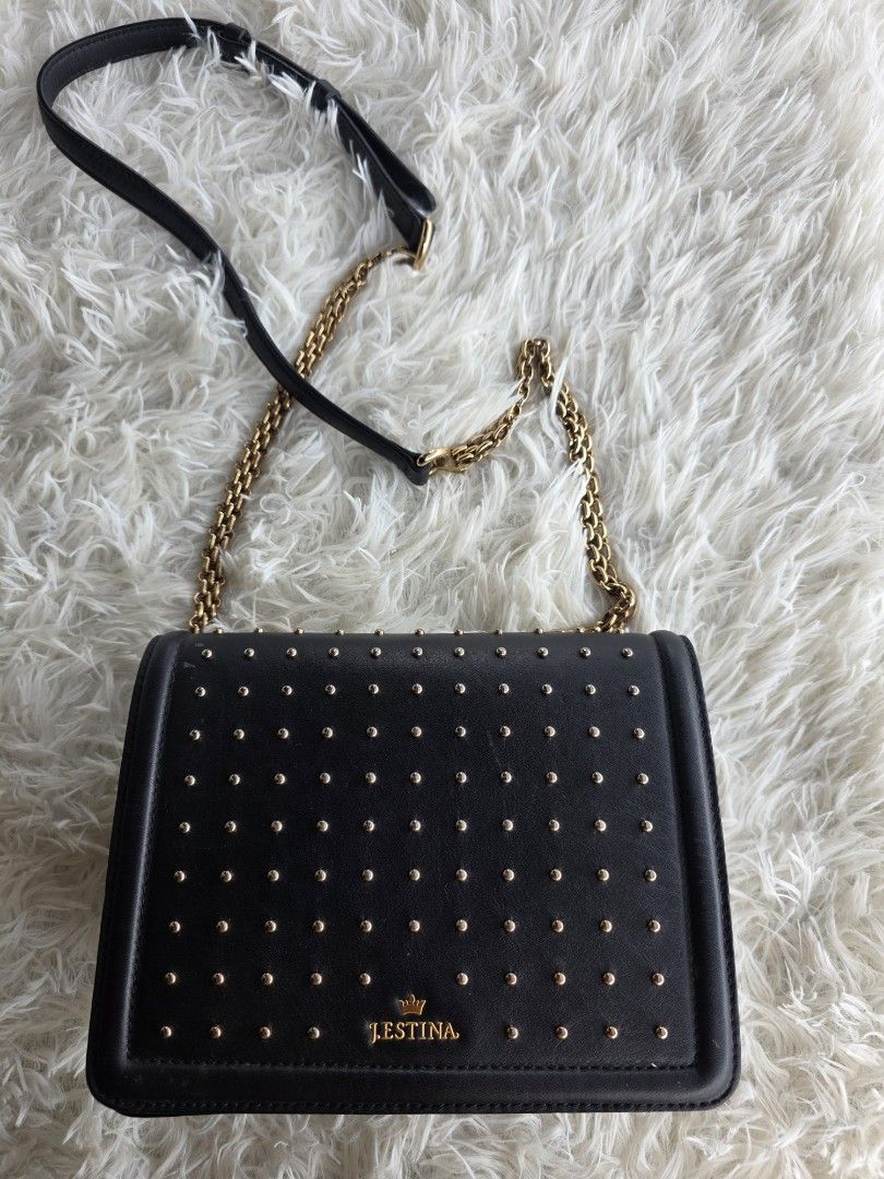 j.estina Black Studded Chain Shoulder Bag (Category: Shoulder Bags) located in Lemery. Submitted by venus23 (Listing ID 1455325828, Image 1). Description: - Brand: J.ESTINA - Color: Black - Design: All-over gold stud embellishments - Strap: Gold chain strap (note: some wear and tear on one side) - Features: Back slip pocket - Approximate Dimensions: 7 inches (height) x 5.5 inches (width).
