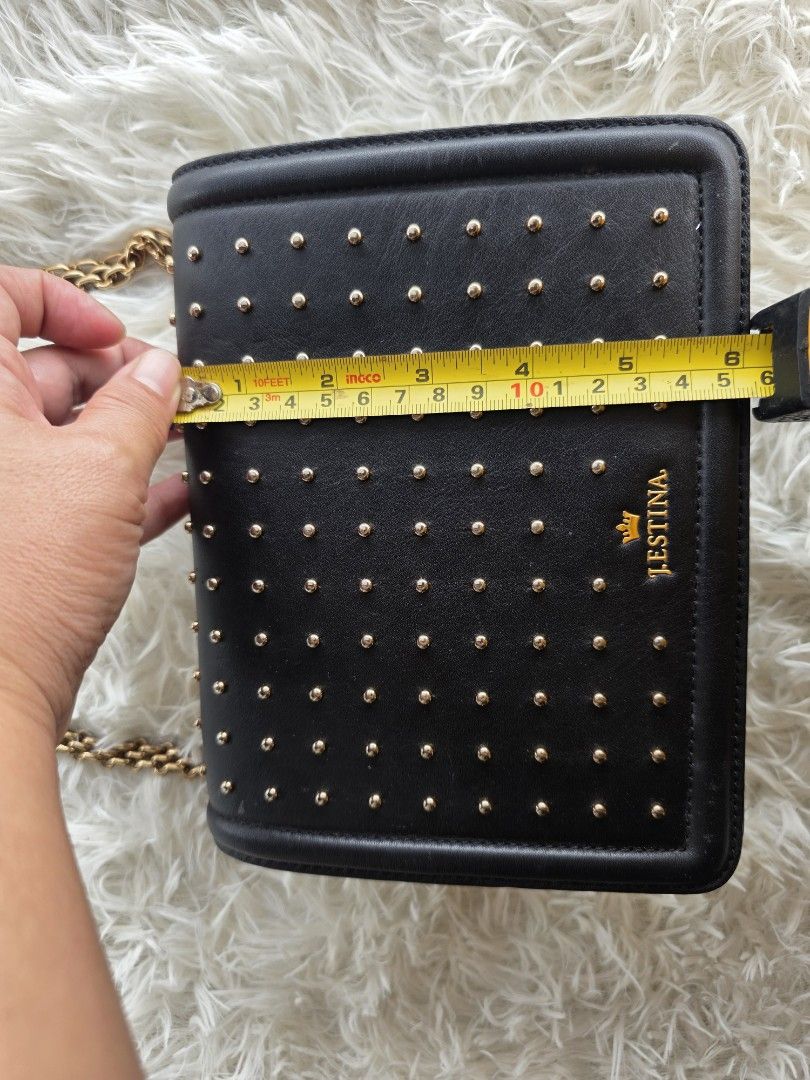 j.estina Black Studded Chain Shoulder Bag (Category: Shoulder Bags) located in Lemery. Submitted by venus23 (Listing ID 1455325828, Image 2). Description: - Brand: J.ESTINA - Color: Black - Design: All-over gold stud embellishments - Strap: Gold chain strap (note: some wear and tear on one side) - Features: Back slip pocket - Approximate Dimensions: 7 inches (height) x 5.5 inches (width).