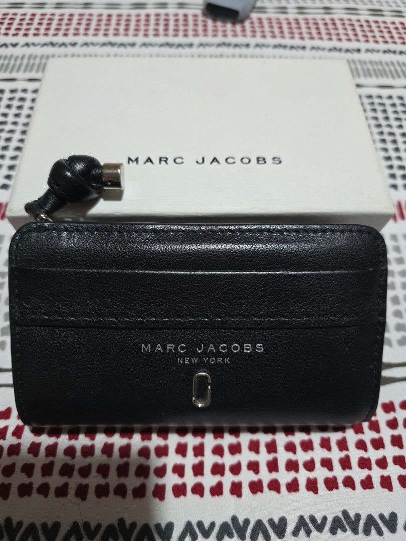 Marc Jacobs Black Leather Bi-Fold Wallet with Box (Category: Luxury Bags & Wallets) located in Las Pinas. Submitted by luxeprelovedstuff (Listing ID 1455390901, Image 1). Description: - Genuine Marc Jacobs black leather bi-fold wallet - Multiple card slots for organization - Secure zipped compartment for coins or essentials - Comes with original box - Interior is clean and well-maintained - Unique knot detail on the zipper pull complete with box.
