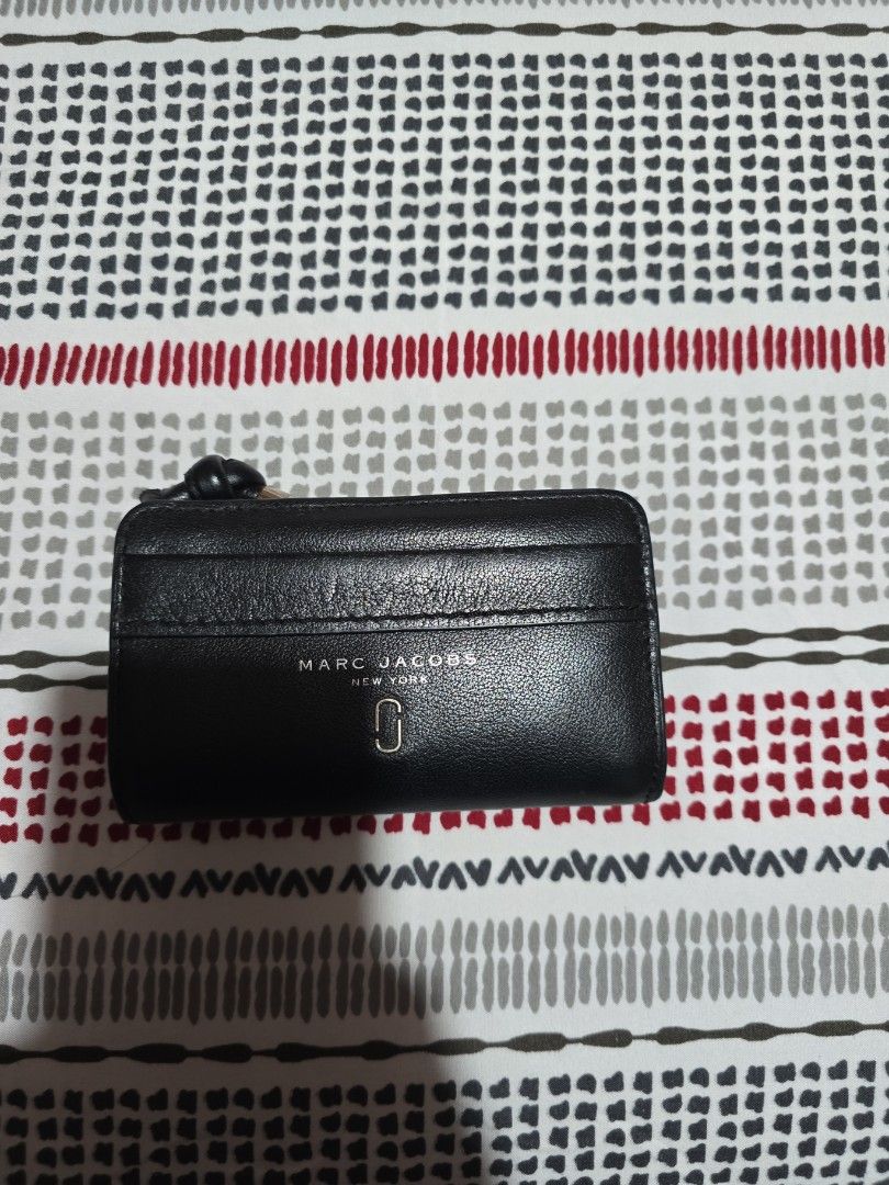 Marc Jacobs Black Leather Bi-Fold Wallet with Box (Category: Luxury Bags & Wallets) located in Las Pinas. Submitted by luxeprelovedstuff (Listing ID 1455390901, Image 3). Description: - Genuine Marc Jacobs black leather bi-fold wallet - Multiple card slots for organization - Secure zipped compartment for coins or essentials - Comes with original box - Interior is clean and well-maintained - Unique knot detail on the zipper pull complete with box.