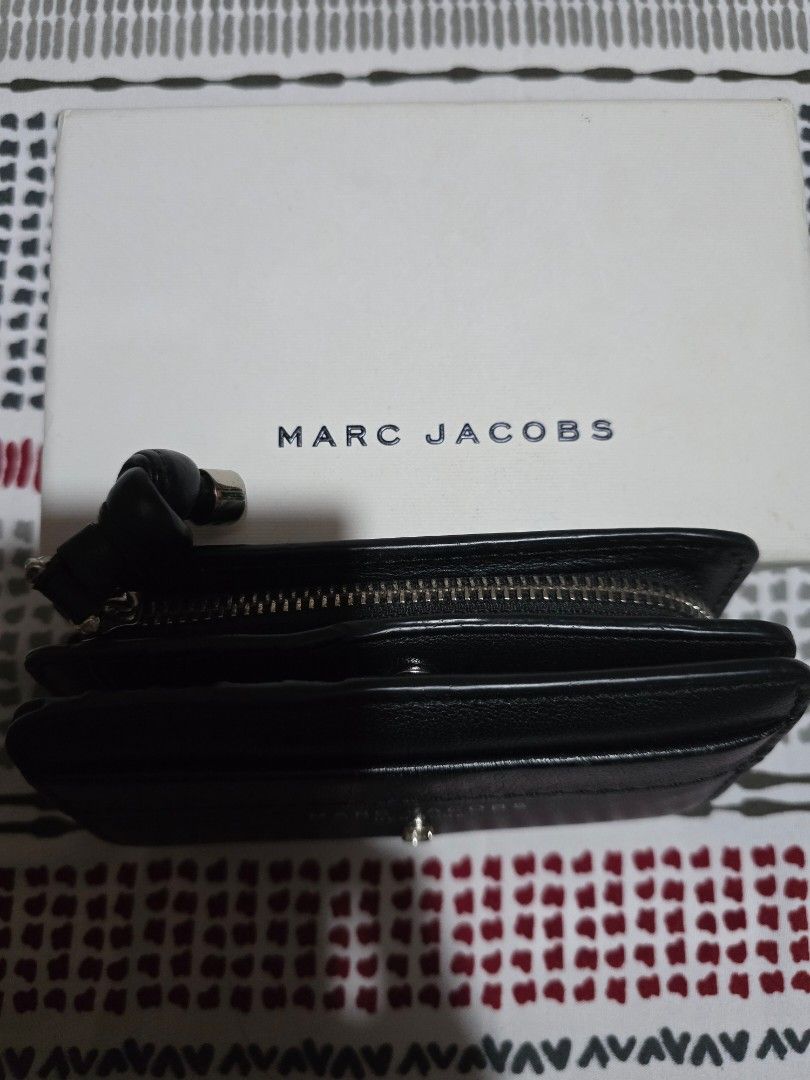 Marc Jacobs Black Leather Bi-Fold Wallet with Box (Category: Luxury Bags & Wallets) located in Las Pinas. Submitted by luxeprelovedstuff (Listing ID 1455390901, Image 2). Description: - Genuine Marc Jacobs black leather bi-fold wallet - Multiple card slots for organization - Secure zipped compartment for coins or essentials - Comes with original box - Interior is clean and well-maintained - Unique knot detail on the zipper pull complete with box.