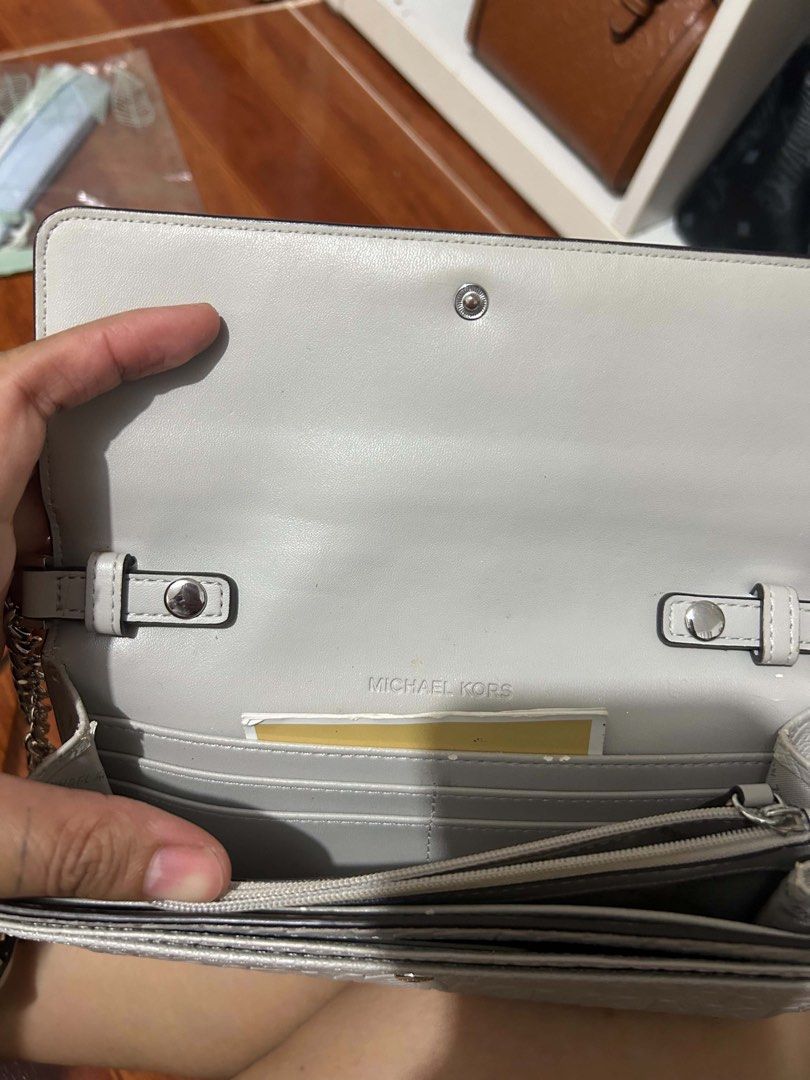 Michael Kors Wallet Clutch (Category: Luxury Bags & Wallets) located in Caloocan City. Submitted by jill262626 (Listing ID 1455331533, Image 3). Description: - Michael Kors wallet in light grey - Features embossed MK logo pattern on the front flap - Multiple card slots inside - Includes a zip pocket - Comes with a detachable strap - Ideal for carrying your daily essentials -authentic.