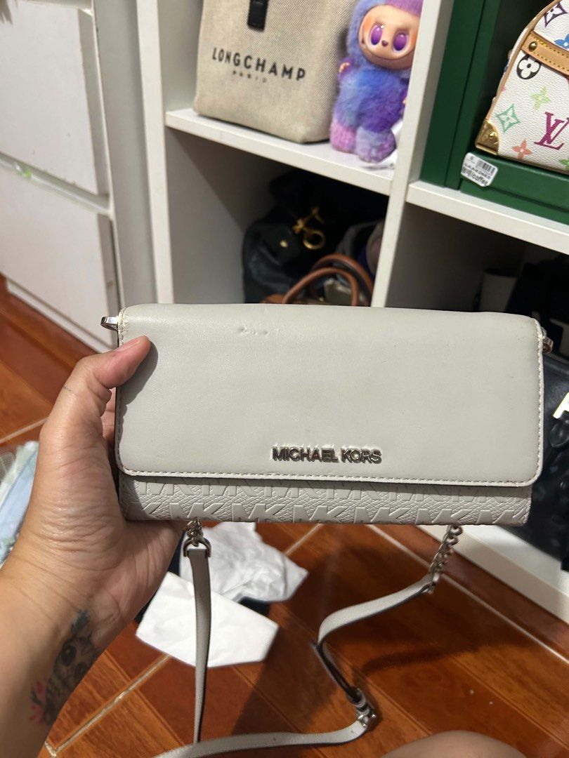 Michael Kors Wallet Clutch (Category: Luxury Bags & Wallets) located in Caloocan City. Submitted by jill262626 (Listing ID 1455331533, Image 1). Description: - Michael Kors wallet in light grey - Features embossed MK logo pattern on the front flap - Multiple card slots inside - Includes a zip pocket - Comes with a detachable strap - Ideal for carrying your daily essentials -authentic.