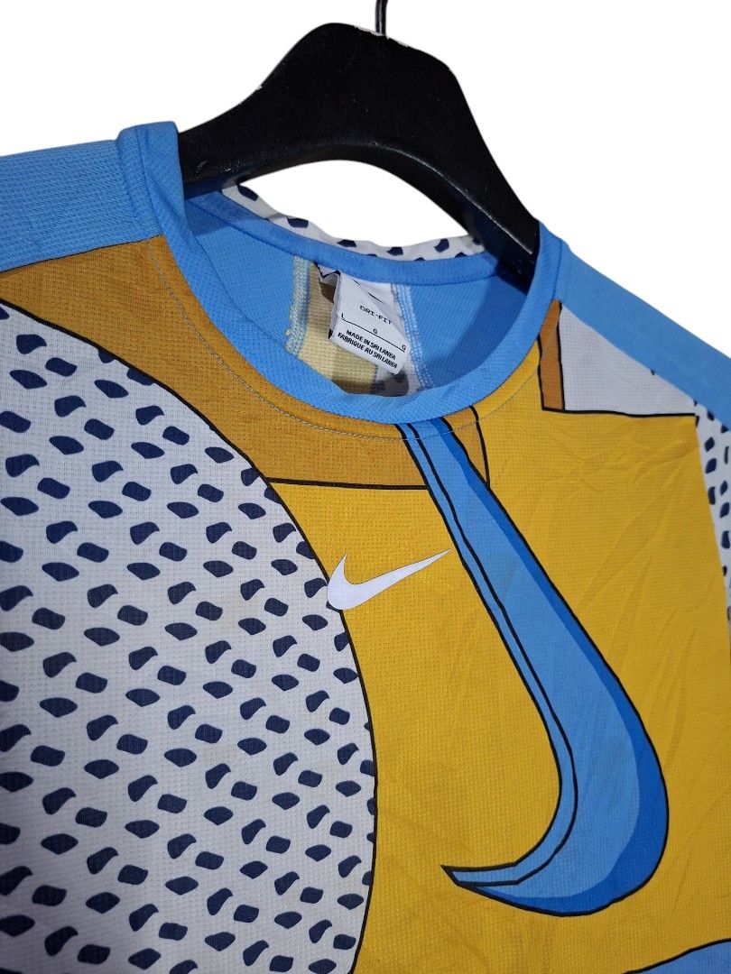Nike Dri-FIT Center Swoosh (Category: Tshirts & Polo Shirts ) located in San Juan (Cabalian). Submitted by ec8thrift (Listing ID 1455438855, Image 3). Description: - Brand: Nike - Style: Graphic T-Shirt - Design: Vibrant abstract print (blue, yellow, white) with "Just Do It" slogan - Material: Dri-FIT for comfort and sweat-wicking - Size: S - Ideal for: Workouts, sports, casual wear.