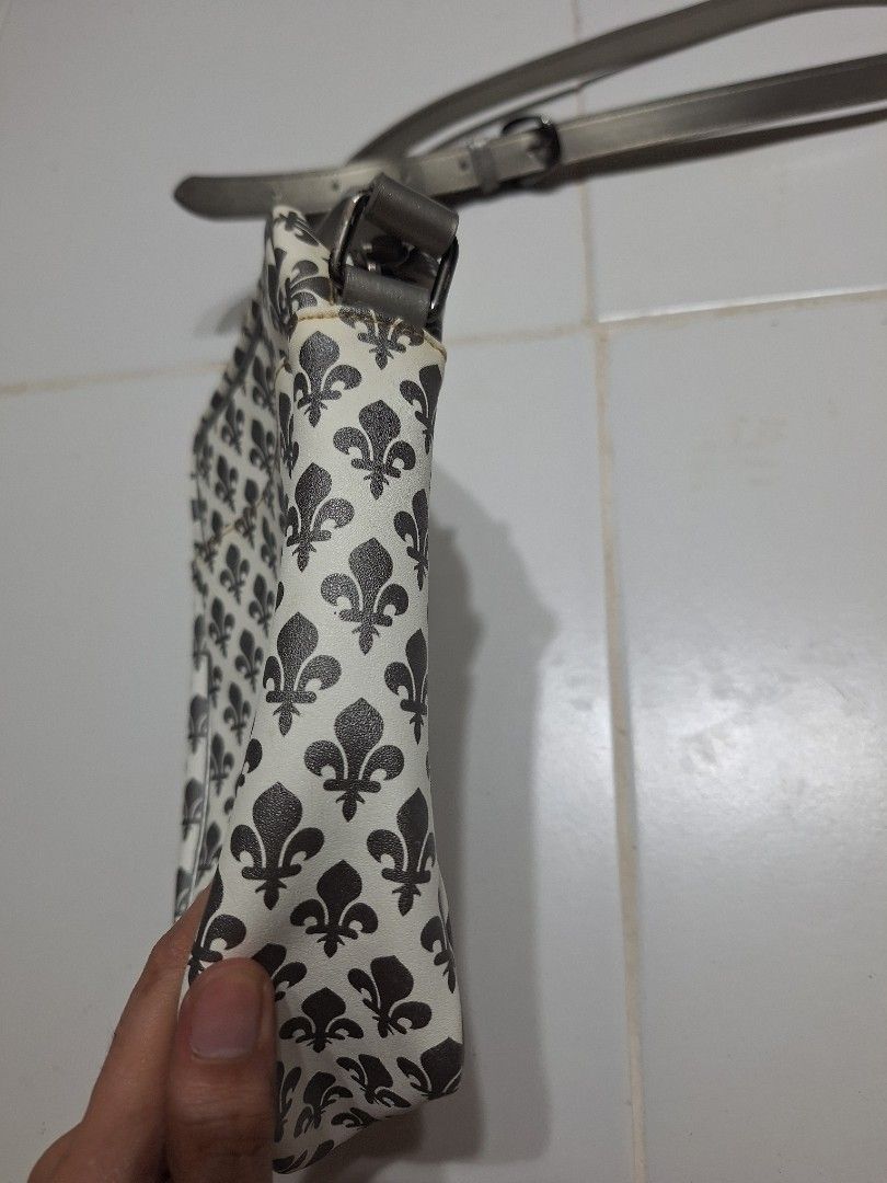 Patrick Cox White and Grey Fleur-de-lis Pattern Crossbody Bag (Category: Cross-body Bags) located in Las Pinas. Submitted by second.founds (Listing ID 1455398247, Image 2). Description: Patrick Cox sling bag -6 inches by 8.5 inches Strap - 57 inches -What you see is what you get. -Lightly used -Mop: gcash / bdo -courier: ggx - Stylish white crossbody bag - Features a grey fleur-de-lis pattern - Adjustable grey strap for comfortable wear - Secure 