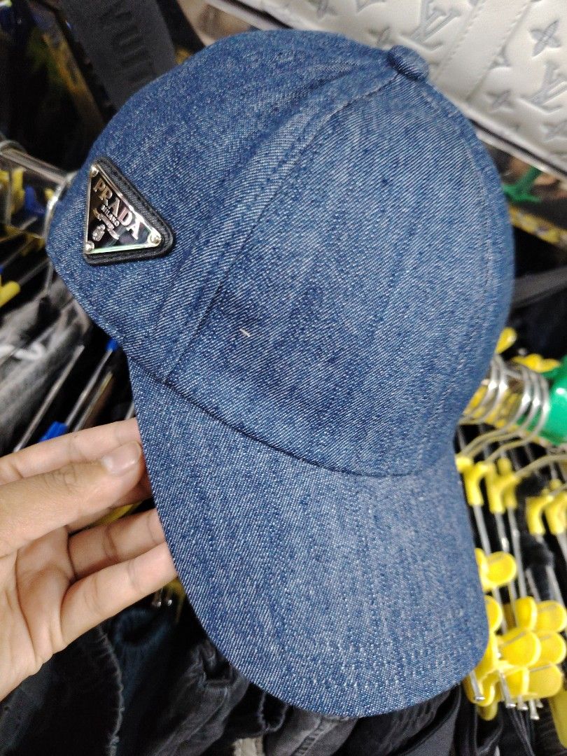 Prada Denim Baseball Cap (Category: Caps & Hats) located in Baguio. Submitted by XycerlynCLXN (Listing ID 1455323285, Image 1). Description: - Prada denim cap - Features the iconic Prada triangle logo on the front - Size: Medium (M) - Made in Italy - Ideal for everyday wear and adding a touch of luxury to your casual outfits.