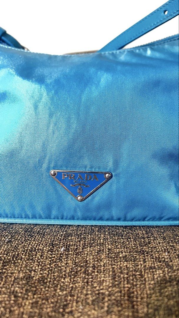 Prada Tessuto Nylon Shoulder Bag (Category: Shoulder Bags) located in Manila. Submitted by source.selection (Listing ID 1455372453, Image 2). Description: This is a bright turquoise-blue Prada Tessuto nylon shoulder bag featuring an adjustable strap and the iconic enameled metal triangle logo. Based on the resale market, realistically expect to list pre-loved Prada Tessuto Nylon Shoulder Bag for anywhere between $400 to $800 USD (approximately ₱2