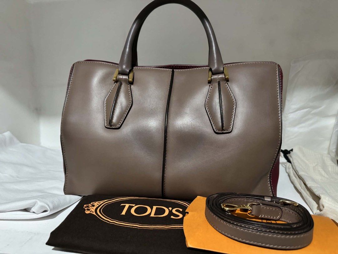 Tod's Leather Tote Bag (Category: Luxury Bags & Wallets) located in Santa Rosa. Submitted by bumfinds (Listing ID 1455437360, Image 1). Description: - Authentic Tod's leather tote bag - Stylish two-tone design: taupe and burgundy - Elegant gold hardware accents - Includes a detachable shoulder strap for versatility - Comes with original dust bag - Ideal for everyday use and carrying your essentials.