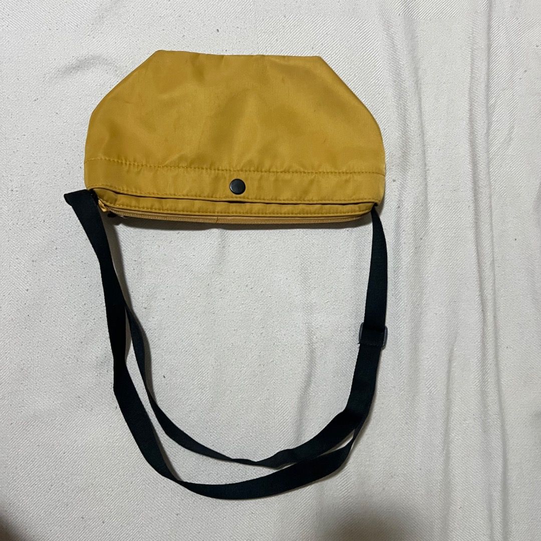 Uniqlo Nylon Mini Dumpling Sling Shoulder Bag - Yellow (Category: Cross-body Bags) located in Quezon City. Submitted by horangidee (Listing ID 1448663193, Image 2). Description: Well loved bag but still in great condition! Originally a nice yellow shade, my lighting's just horrible (feel free to ask for photos!) 💛 Nylon material, water resistant and easy to clean 💛 Adjustable straps, can make it crossbody or shoulder bag 💛 Compartments with bu