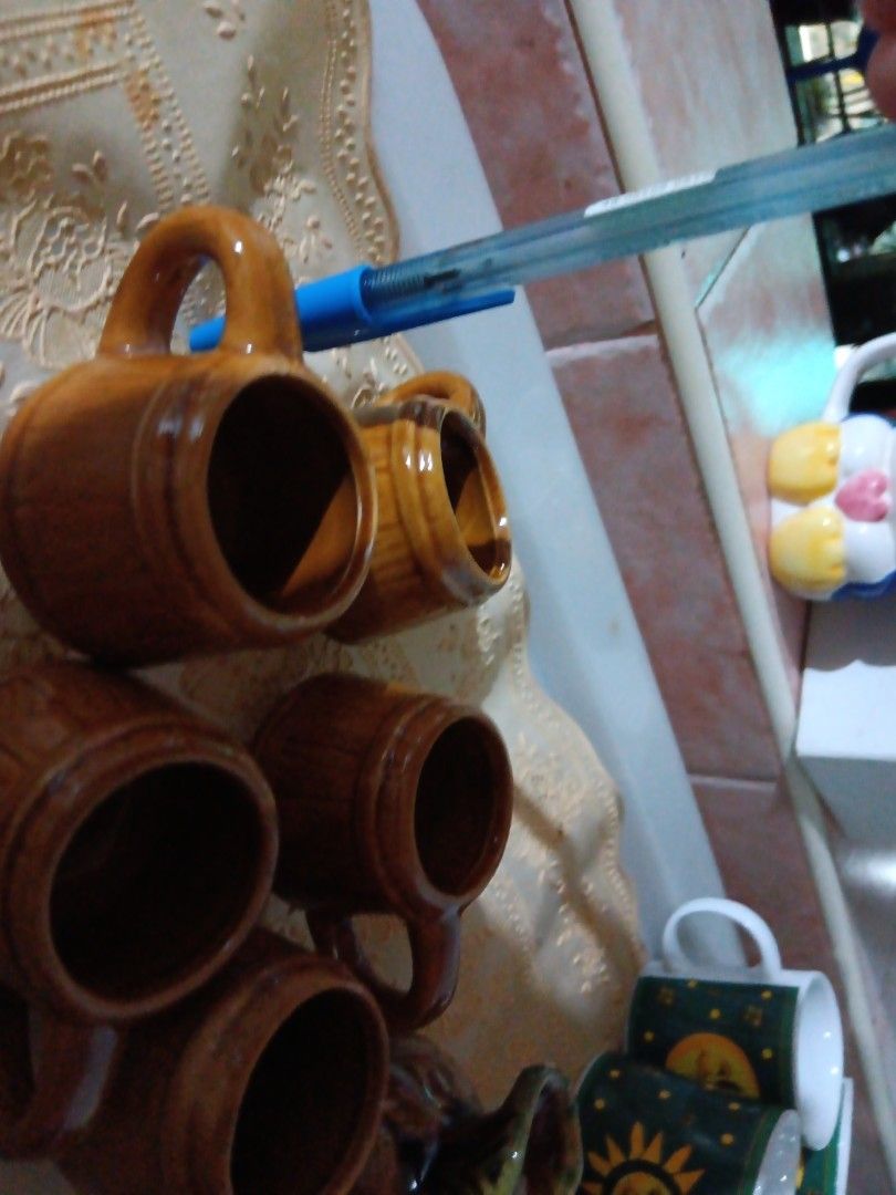 Vintage Ceramic Mugs Set (Category: Coffee & Tea Tableware) located in Pasay City. Submitted by keenfox.a73ed0 (Listing ID 1455335919, Image 2). Description: - Set of 5 vintage ceramic mugs - Rustic brown glaze - Barrel-like design - Perfect for coffee or tea - Includes decorative pitcher - Green and brown glaze on pitcher - Great for display or use - Unique collectible pieces 1.5 inches in height.