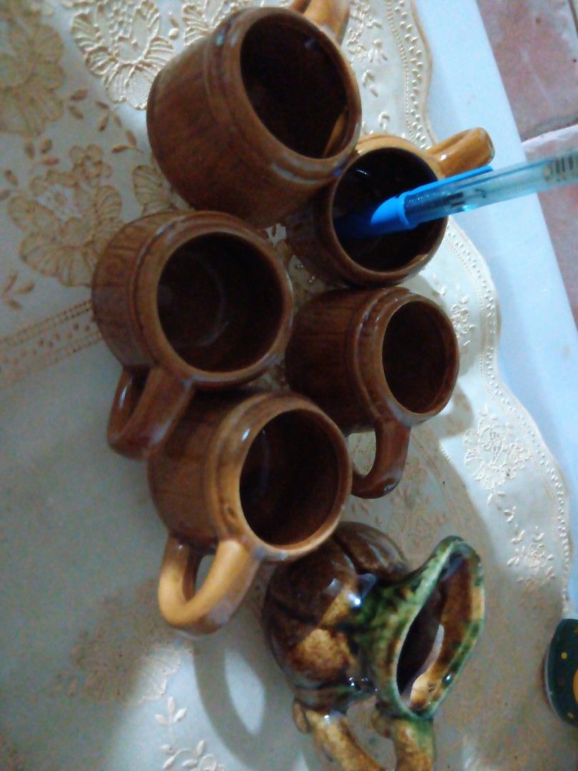 Vintage Ceramic Mugs Set (Category: Coffee & Tea Tableware) located in Pasay City. Submitted by keenfox.a73ed0 (Listing ID 1455335919, Image 3). Description: - Set of 5 vintage ceramic mugs - Rustic brown glaze - Barrel-like design - Perfect for coffee or tea - Includes decorative pitcher - Green and brown glaze on pitcher - Great for display or use - Unique collectible pieces 1.5 inches in height.