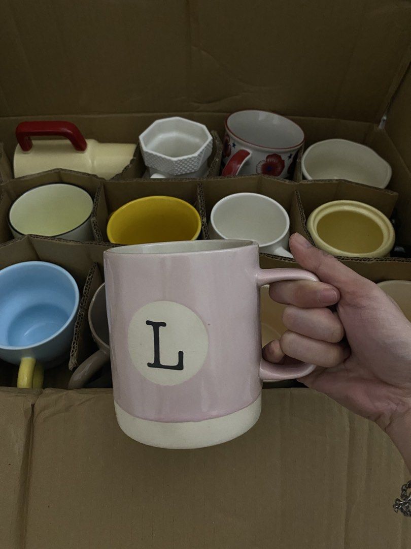 Assorted Ceramic Mugs - Cute Designs & Plain Styles (Category: Coffee & Tea Tableware) located in Dasmarinas. Submitted by andreachalamet (Listing ID 1455524681, Image 3). Description: - Assorted ceramic mugs available. - Colors include pastel pink and blue. - Fun designs: cat with flowers, letter 'L' mug. - Features unique textures and colored handles on some mugs. - Ideal for coffee, tea, or hot chocolate. - Makes a great gift or addition to yo