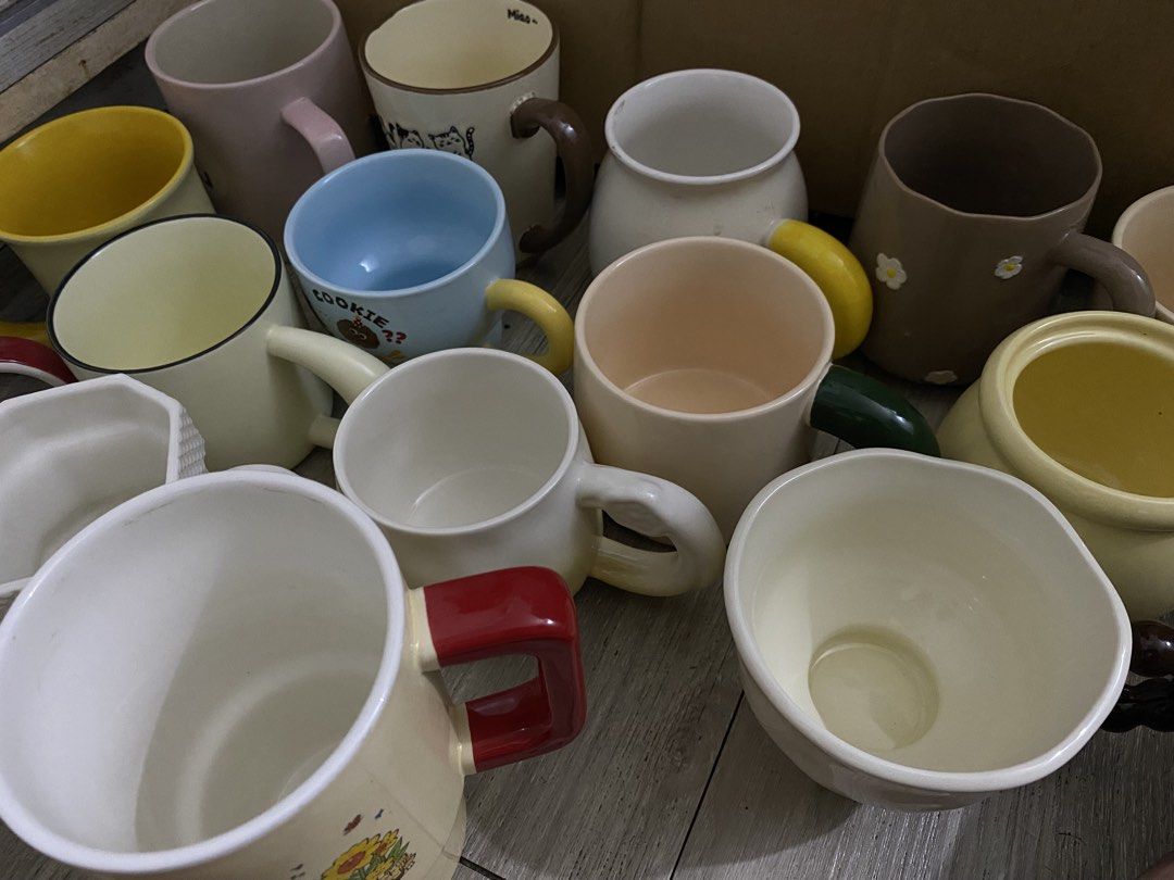 Assorted Ceramic Mugs - Cute Designs & Plain Styles (Category: Coffee & Tea Tableware) located in Dasmarinas. Submitted by andreachalamet (Listing ID 1455524681, Image 1). Description: - Assorted ceramic mugs available. - Colors include pastel pink and blue. - Fun designs: cat with flowers, letter 'L' mug. - Features unique textures and colored handles on some mugs. - Ideal for coffee, tea, or hot chocolate. - Makes a great gift or addition to yo