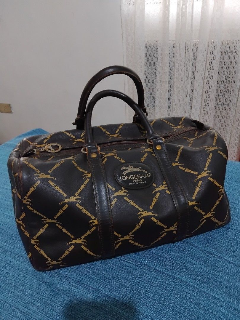 Authentic Longchamp Vintage Monogram Leather Boston Bag in 30 (Category: Luxury Bags & Wallets) located in Manila. Submitted by daronandtruffles (Listing ID 1455586008, Image 1). Description: - Vintage Longchamp satchel bag - Classic gold monogram print on dark brown leather - Genuine leather handles and trim - Secure zipper closure - Authentically made in France Material: Full grain leather inside and out Faded tag but it is Made in France Dimen