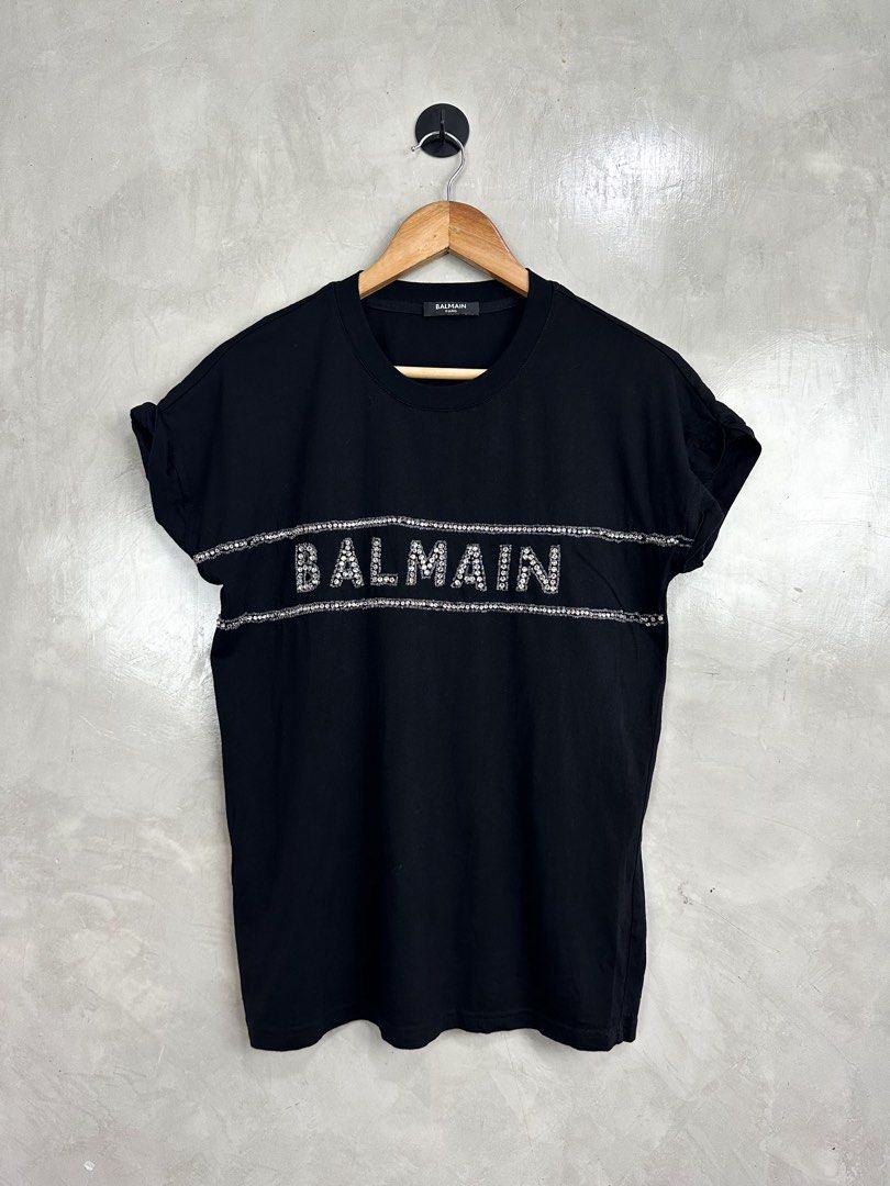 BALMAIN - Crystal Embellished Logo Shirt (Category: Shirts) located in Cavite. Submitted by hand.picked (Listing ID 1455620816, Image 1). Description: BALMAIN - Crystal Embellished Logo Shirt Size: Medium Measurement: 19” Width / 25” Length Condition: Excellent Note: Missing some stones.