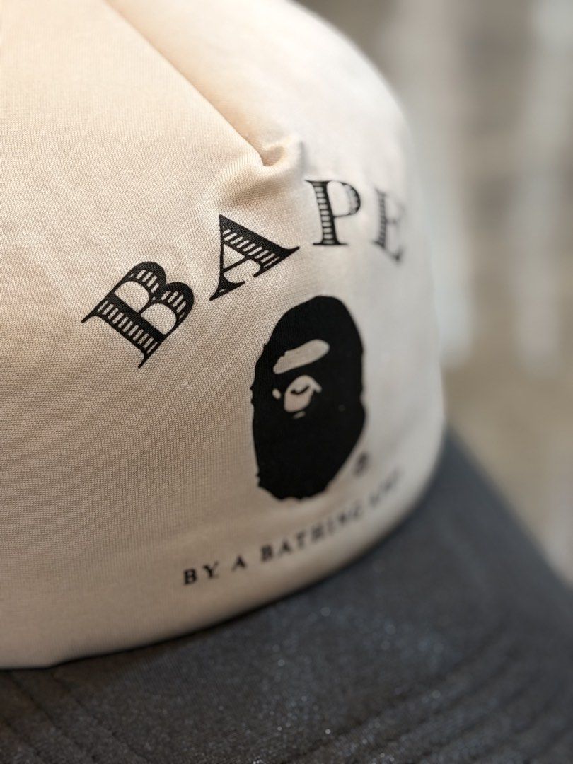 BAPE By A Bathing Ape Trucker Cap (Category: Caps & Hats) located in Pasig City. Submitted by letmethrift88 (Listing ID 1455636467, Image 2). Description: - Authentic BAPE trucker cap - Cream front panel featuring iconic BAPE logo and ape head graphic - Breathable grey mesh back - Adjustable snapback closure for a custom fit - Ideal for adding a streetwear edge to your casual outfits.