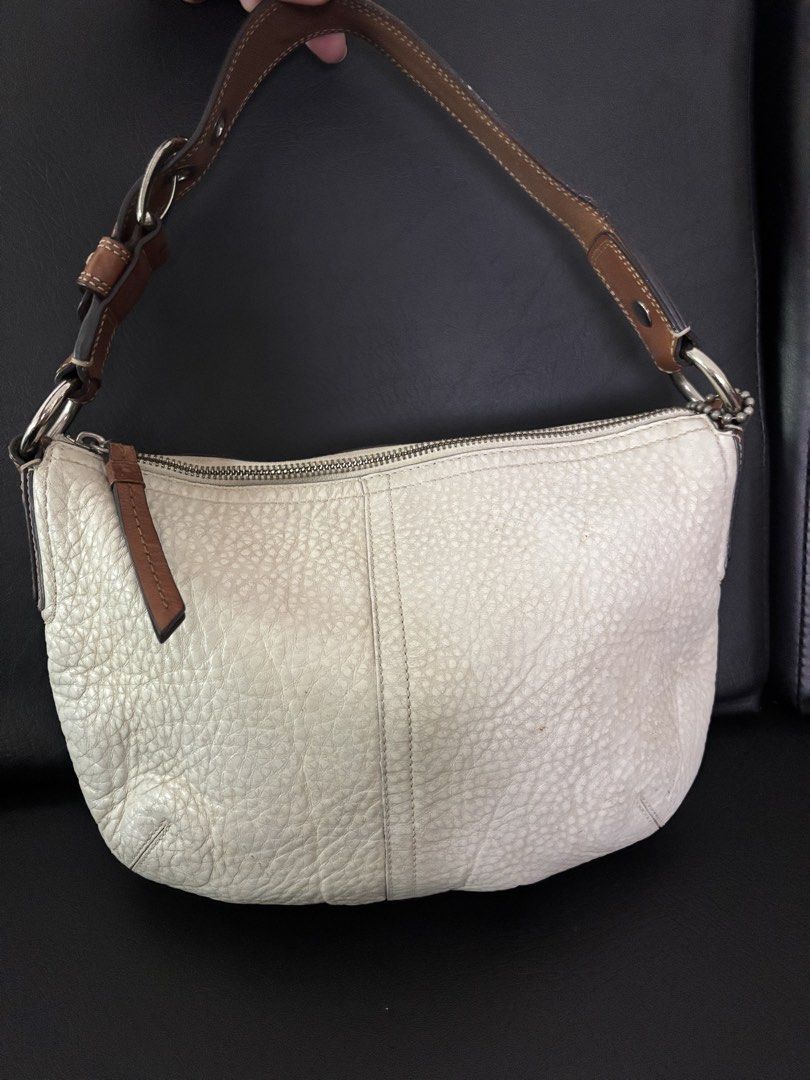 Coach Leather Hobo Shoulder Bag Off White (Category: Luxury Bags & Wallets) located in Caloocan City. Submitted by kisyabooknerd (Listing ID 1455600986, Image 1). Description: - Authentic Coach hobo bag - Off-white pebbled leather with brown leather strap and trim - Zipper closure - Front zip pocket - Interior zip and slip pockets - Shows some signs of wear on leather and interior lining.