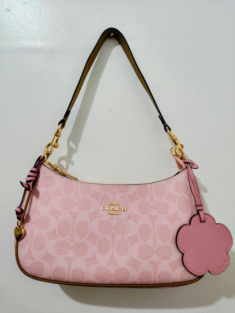 Coach Pink Signature Monogram Shoulder Bag (Category: Shoulder Bags) located in Makati City. Submitted by lovestuvves (Listing ID 1455642165, Image 1). Description: - Cute pink Coach shoulder bag. - Signature monogram pattern all over. - Fun cloud-shaped charm included. - Heart charm also included. - Gold hardware details. - Bright pink interior. - Great for everyday use. - High end quality. But not OG..