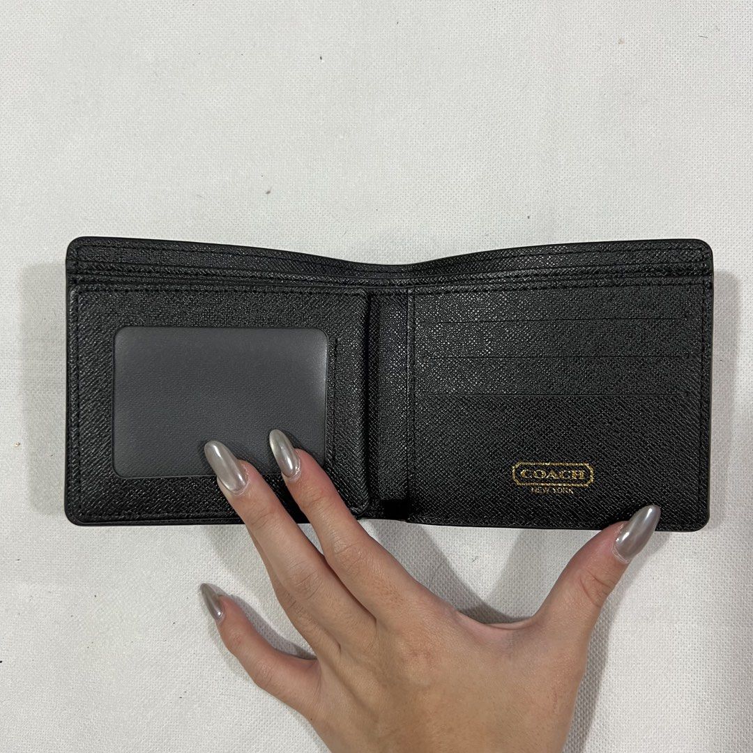 Coach Signature Bifold Wallet (Category: Luxury Bags & Wallets) located in Cavite. Submitted by itsayaaa (Listing ID 1455583367, Image 2). Description: - Classic Coach bifold wallet - Black signature print - Gold Coach New York logo on front - Interior card slots and clear ID window - Ample space for essentials - Includes authenticity QR code.