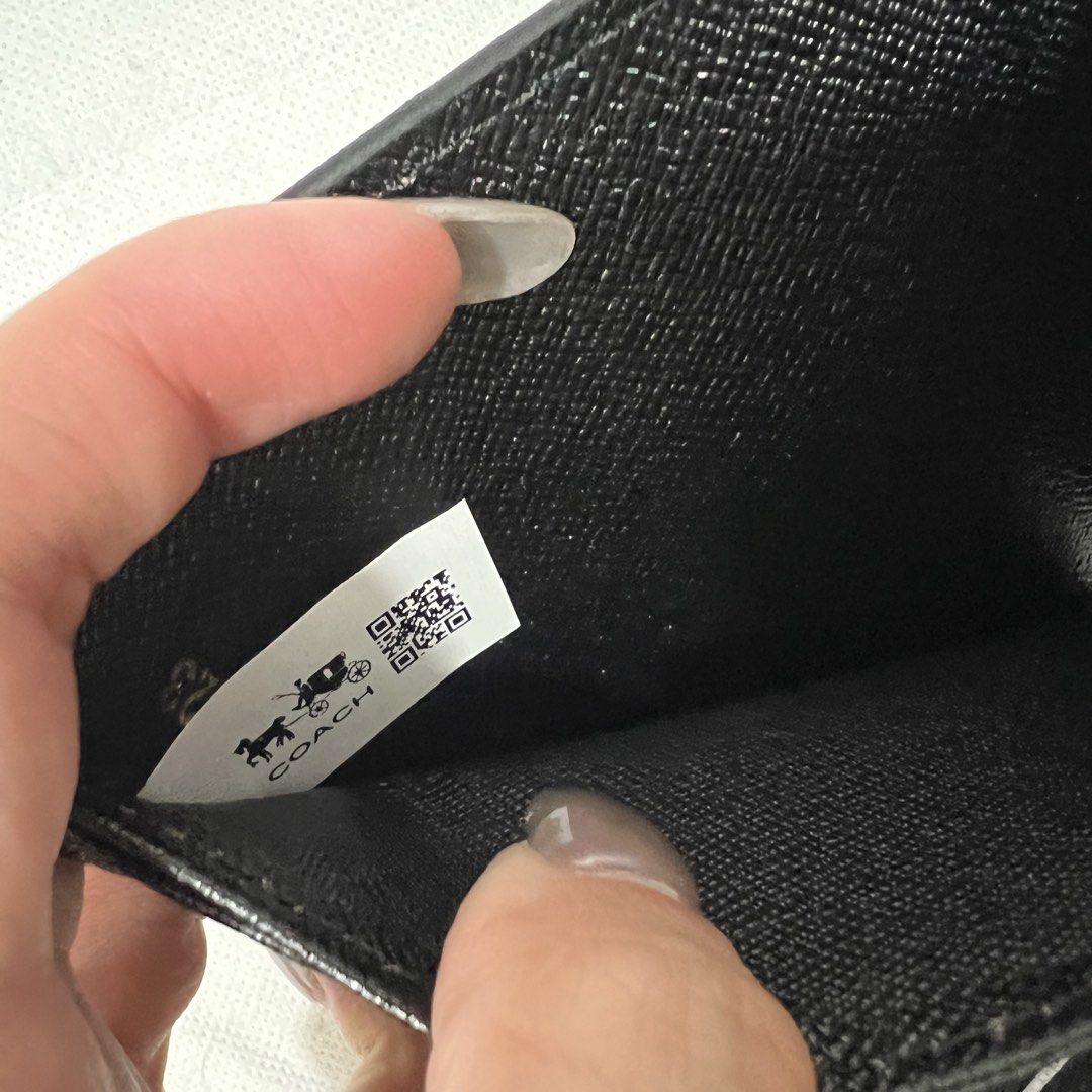 Coach Signature Bifold Wallet (Category: Luxury Bags & Wallets) located in Cavite. Submitted by itsayaaa (Listing ID 1455583367, Image 3). Description: - Classic Coach bifold wallet - Black signature print - Gold Coach New York logo on front - Interior card slots and clear ID window - Ample space for essentials - Includes authenticity QR code.