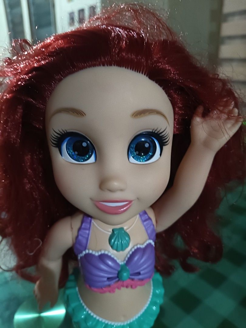 Disney Princess Ariel Singing Doll (Category: Kids Toys) located in Angeles City. Submitted by mysticdeer-32c4 (Listing ID 1455646463, Image 3). Description: - Singing Ariel doll from Disney - Features iconic mermaid tail and seashell top - Long, flowing red hair - Press her seashell necklace to hear her sing - Perfect for any Disney fan - Batteries required (not included).