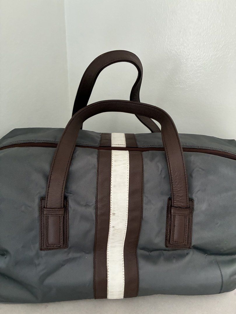 Grey Duffel Bag with Brown Leather Handles (Category: Luxury Bags & Wallets) located in Manila. Submitted by snappyaura (Listing ID 1455618674, Image 3). Description: - Stylish grey duffel bag with brown leather accents. - Features a distinctive white stripe down the middle. - Bright orange interior for easy visibility. - Includes a convenient zippered pocket inside. - Ideal for weekend getaways or gym sessions. - Comfortable handles for easy car